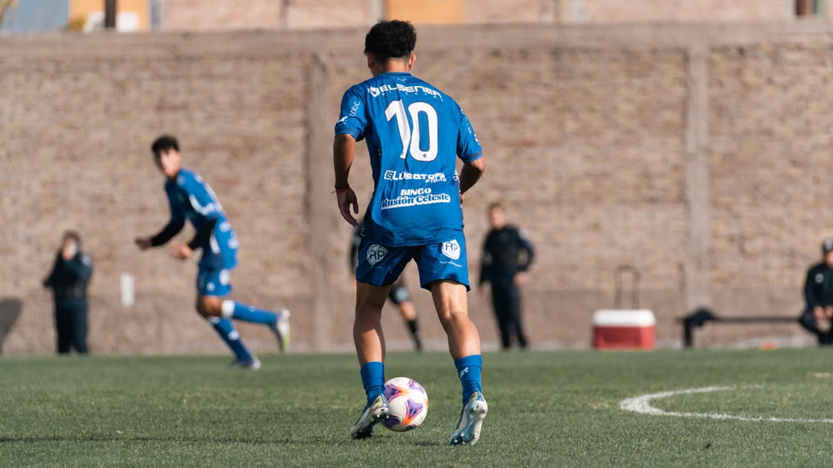 Soccer player wearing number 10 blue jersey during a match on a sunny day.